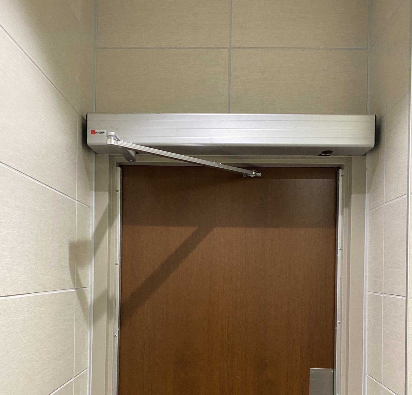 Automatic door operator installed above a commercial door
