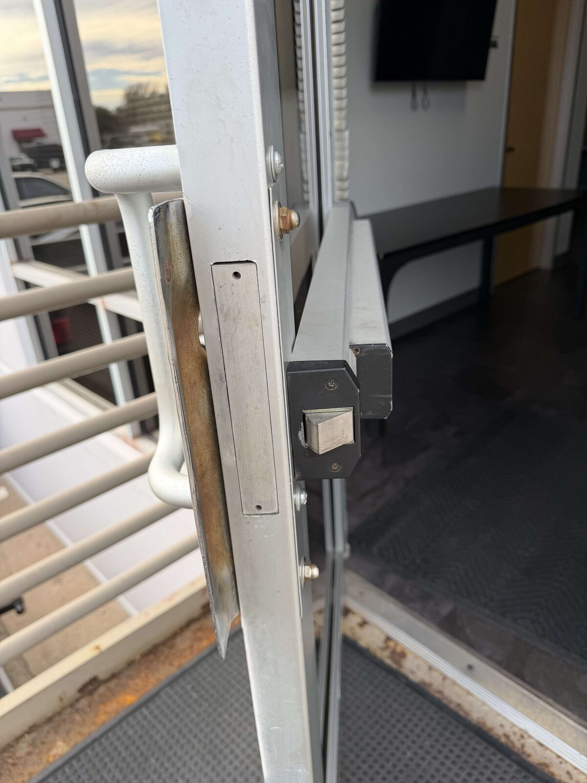 Pull handle with keyed deadbolt cylinder installed on a glass storefront door